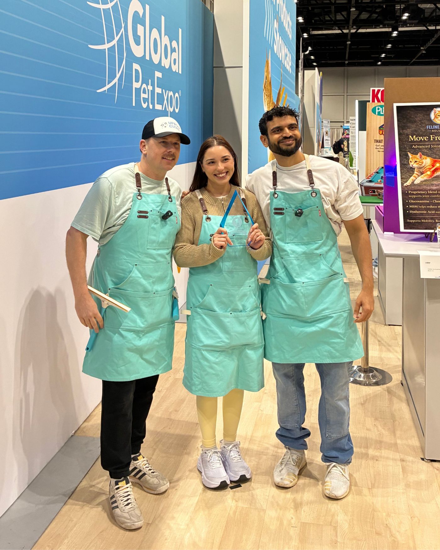 The Uproot Clean team holding the first-place award in front of the Global Pet Expo sign
